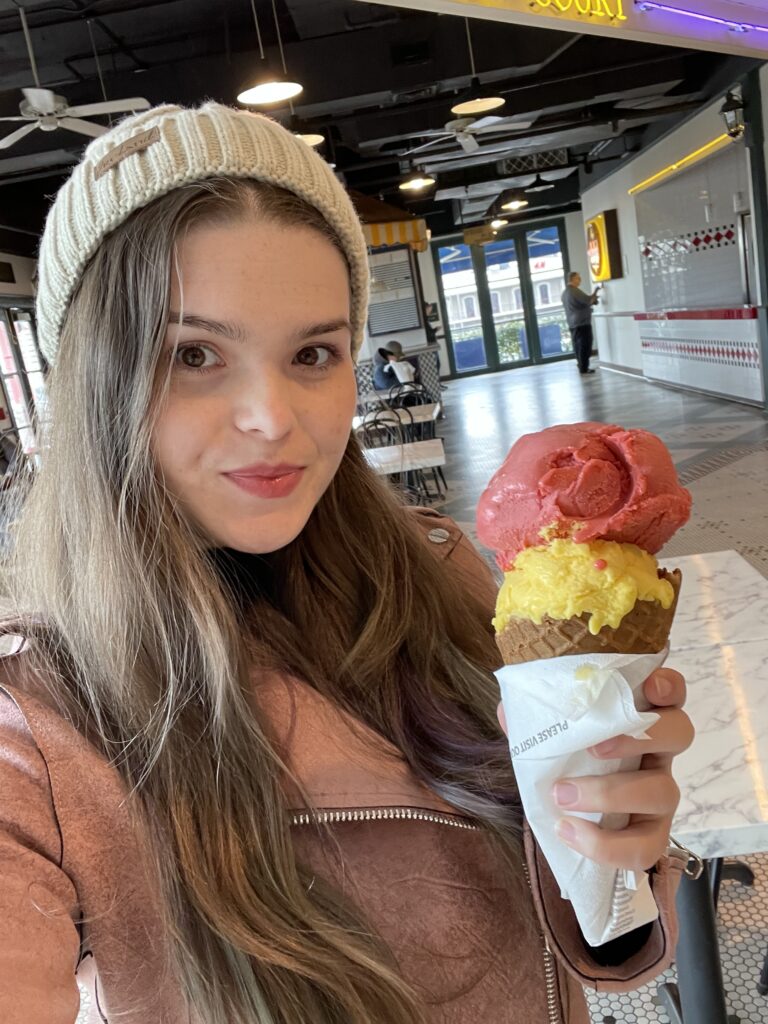 Solo travel girl holding raspberry and lemon sorbet ice cream in New Orleans